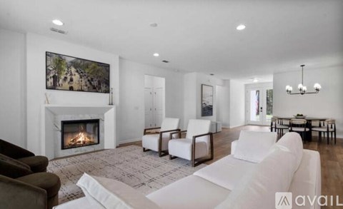 A modern living room with a fireplace and a painting on the wall.