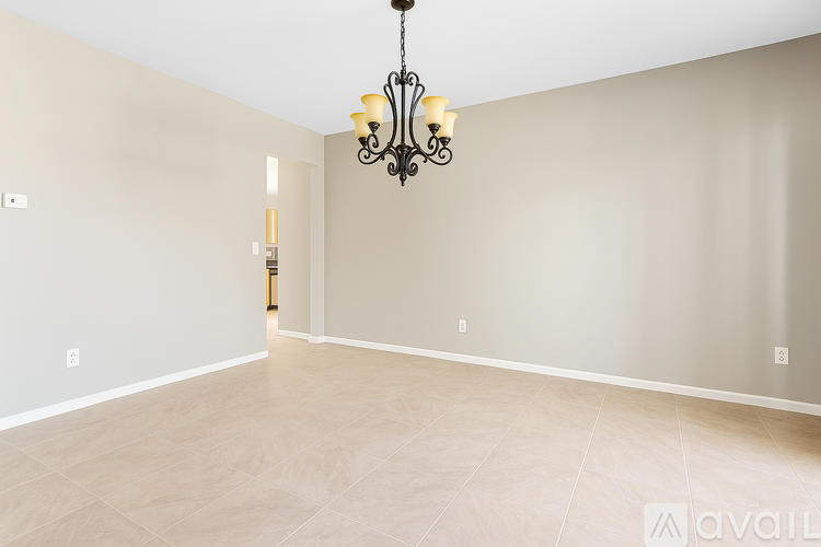 A large empty room with a chandelier hanging from the ceiling.