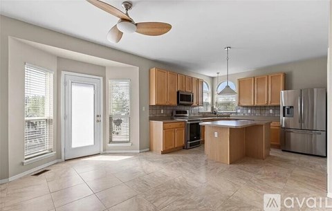 A kitchen with wooden cabinets and a ceiling fan.