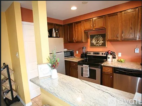 A kitchen with wooden cabinets and a marble countertop.