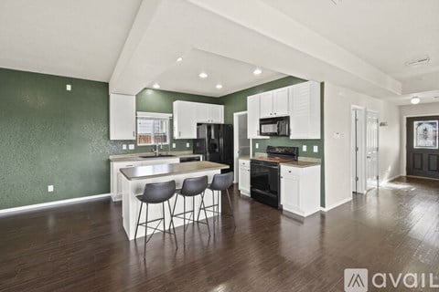 A kitchen with white cabinets and a darker floor.