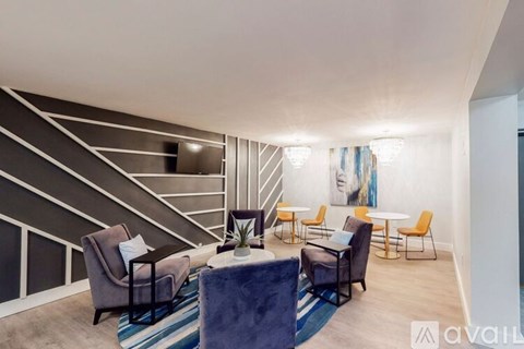 A living room with a staircase and a painting on the wall.