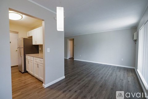 A kitchen with white cabinets and a refrigerator is shown.