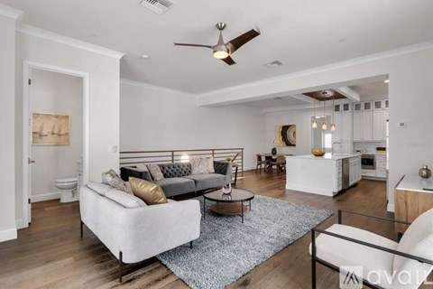 A living room with a grey couch and a white sofa.