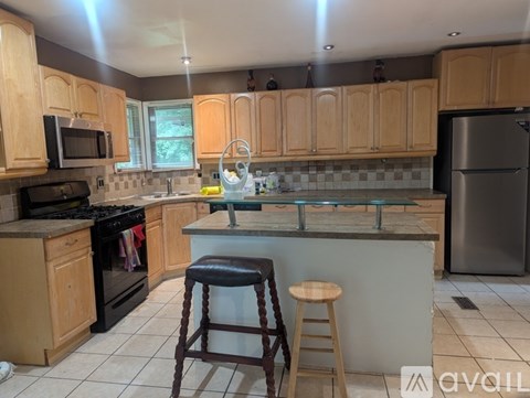 A kitchen with wooden cabinets and a black refrigerator.
