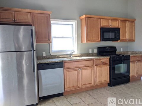 A kitchen with wooden cabinets and a black oven.