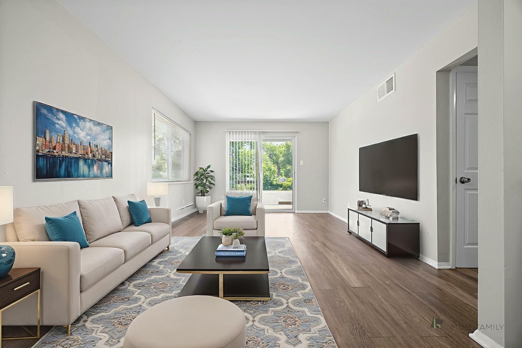 A living room with a white couch, a coffee table, and a painting on the wall.