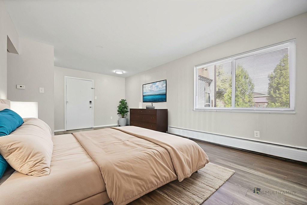 A bedroom with a large bed and a flat screen TV mounted on the wall.