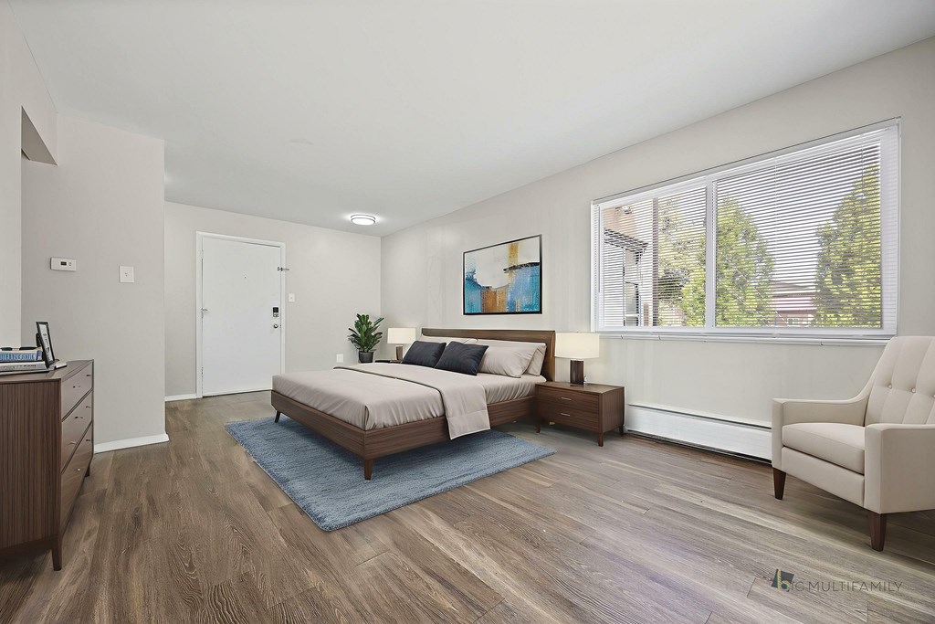 A bedroom with a bed, nightstand, and chair.