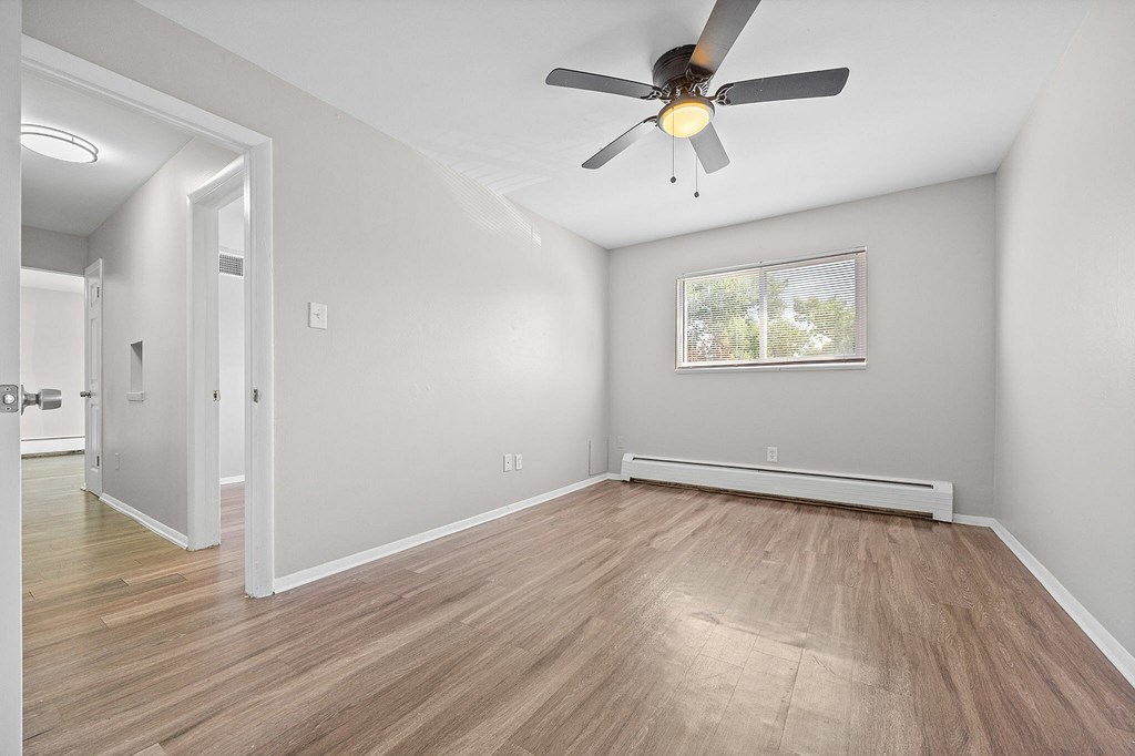 A room with a ceiling fan and a window.