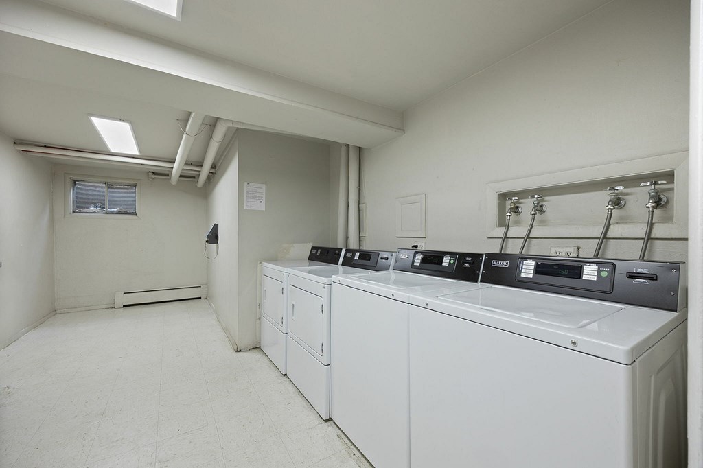 A clean, white room with a washing machine and dryer.