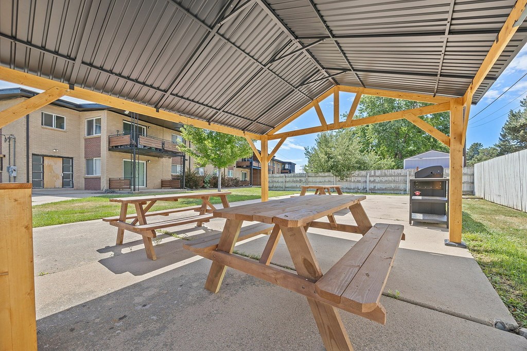 Picnic tables are set up under a canopy.