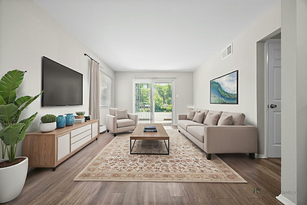 A living room with a couch, a coffee table, a TV, and a painting on the wall.