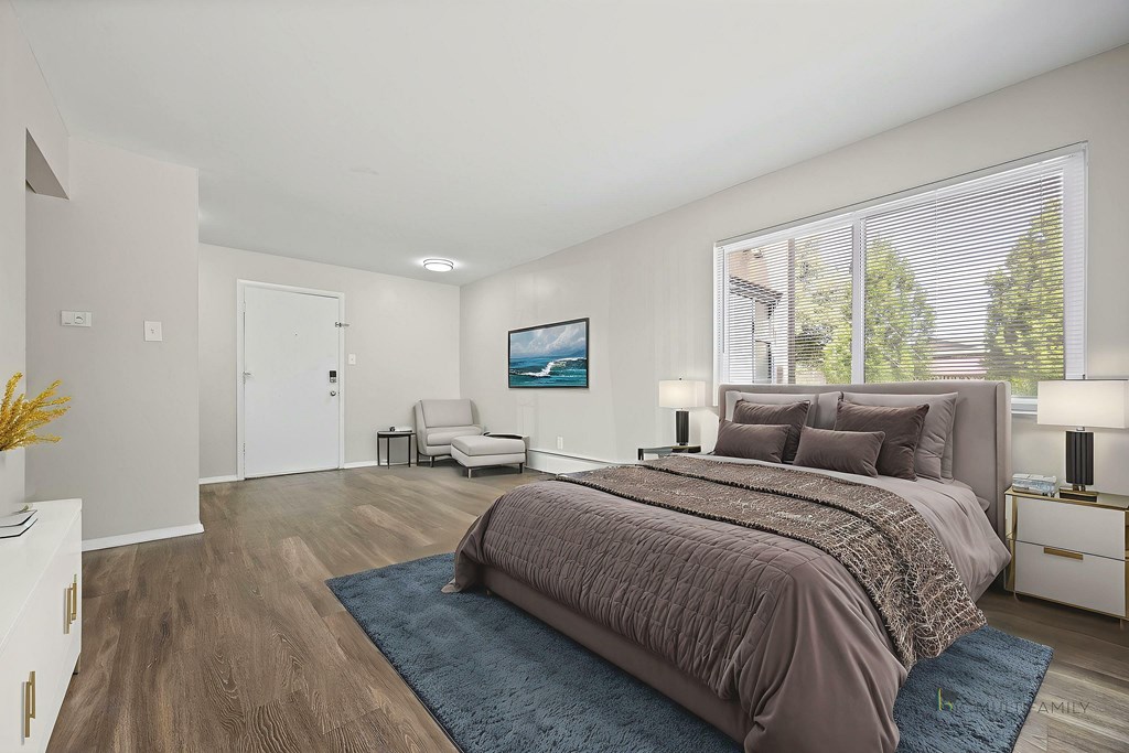 A bedroom with a large bed and a painting on the wall.