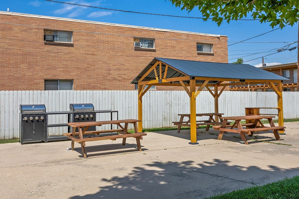 A picnic area with a grill and picnic table.