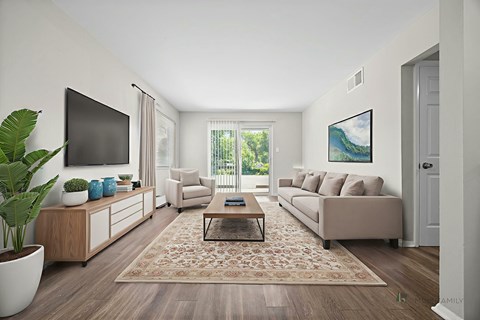 A living room with a couch, a coffee table, a TV, and a painting on the wall.