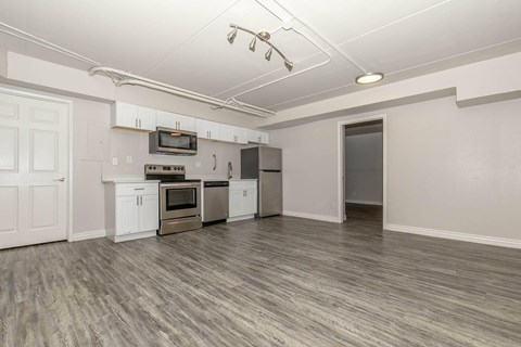 A kitchen with white cabinets and a microwave above the stove.