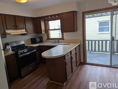 A kitchen with wooden cabinets and a black stove top oven.