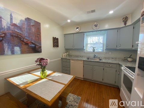 A kitchen with a table in front of a painting of a cityscape.