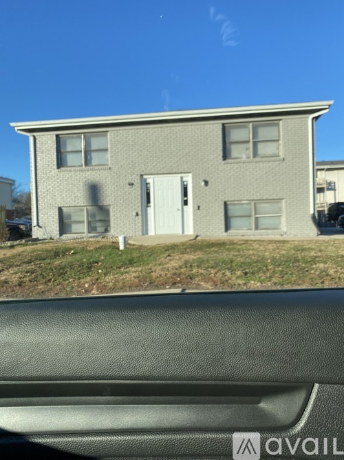 A grey house with a white door and windows.