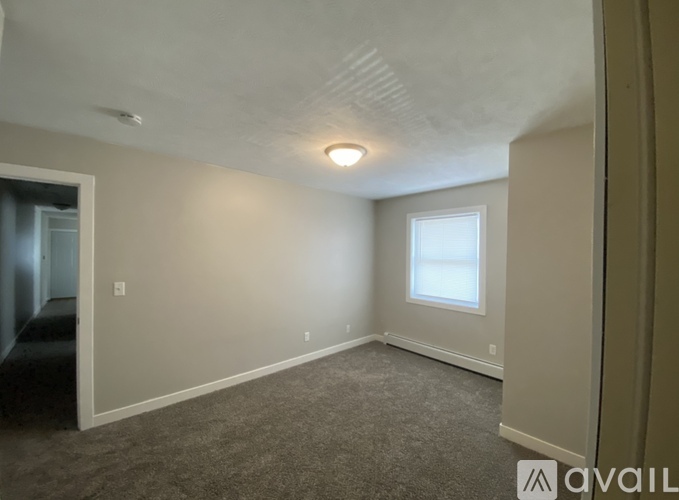 A room with a carpeted floor and a window.