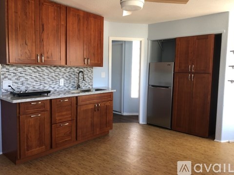 A kitchen with wooden cabinets and a marble countertop.