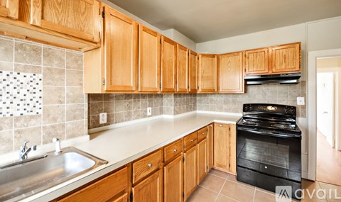 A kitchen with wooden cabinets and a black stove top oven.