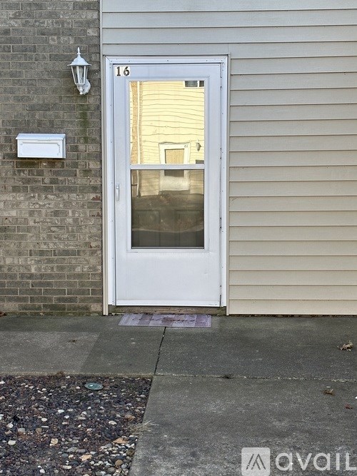 A white door with a glass window is on the side of a building.