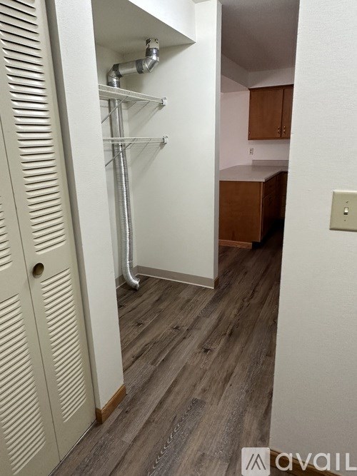 A white door with a vent on the side is open to a kitchen.