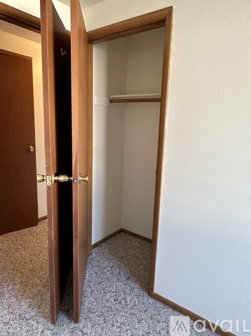 A room with a carpeted floor and a white wall with a door open.