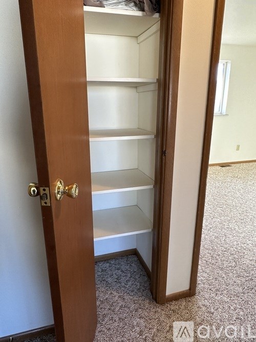 A white shelving unit with a door is open.