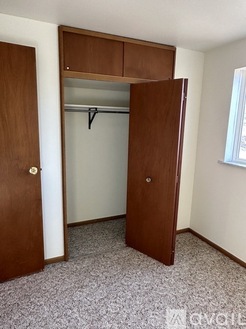 A wooden closet with a hanger is in the room.