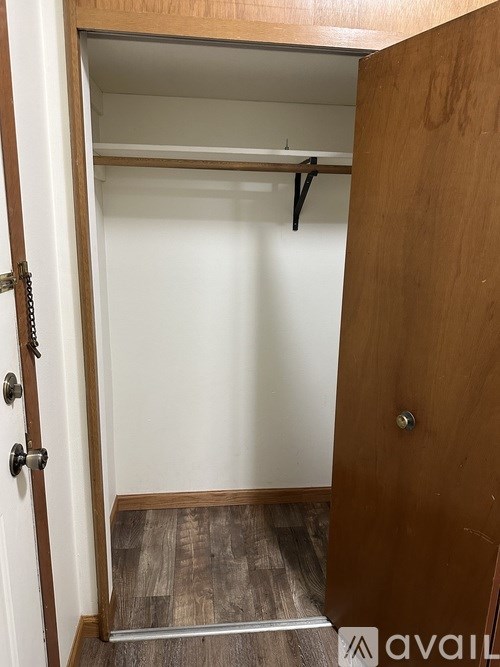 A wooden door with a silver handle and a chain lock.