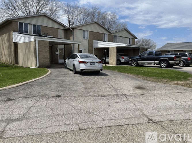 A car is parked in front of a house with a driveway.