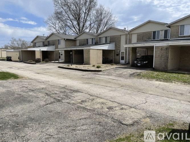 A row of houses with a car parked in the driveway.