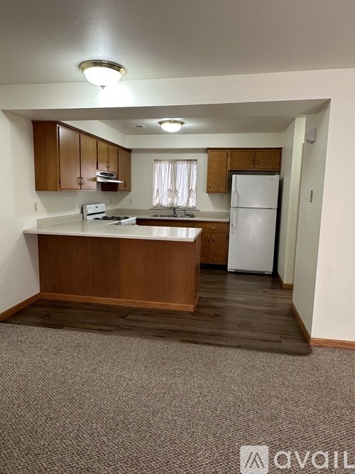 A kitchen with wooden cabinets and a white fridge.
