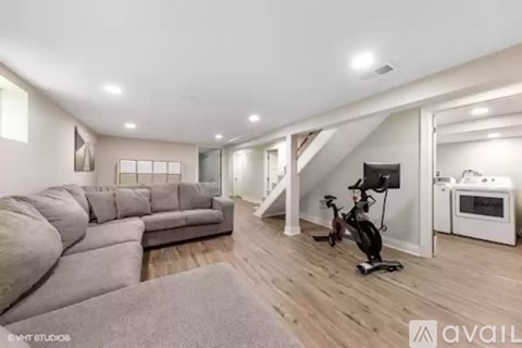A living room with a grey sofa and a wooden floor.