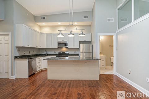 A kitchen with white cabinets and a black countertop.