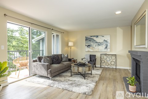 A living room with a grey couch and a fireplace.
