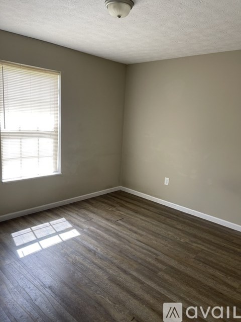A room with a window and wooden flooring.