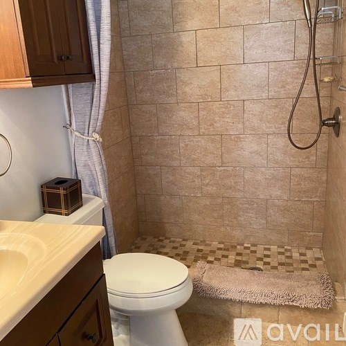 A bathroom with a toilet, sink, and shower.