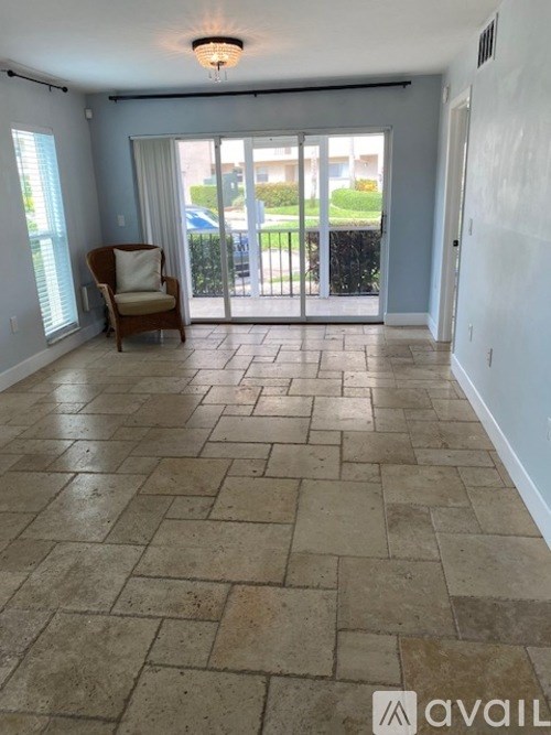 A room with a tiled floor and a sliding glass door leading outside.
