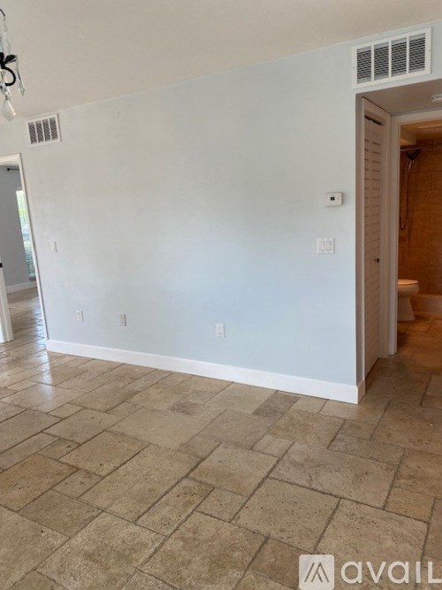 A room with tiled flooring and a doorway leading to another room.