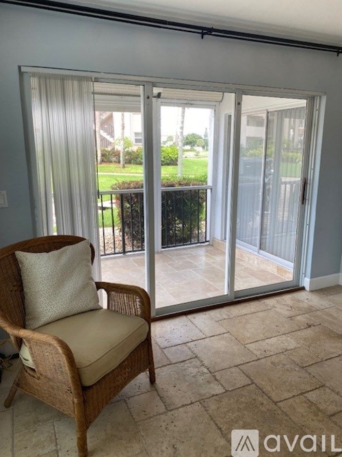 A chair with a cushion is placed in a room with a sliding glass door.