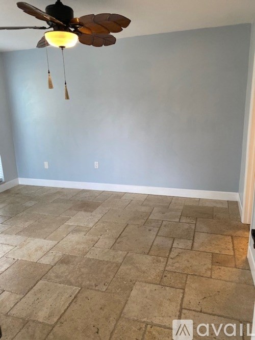 A room with a ceiling fan and tiled flooring.