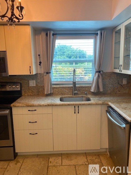A kitchen with a sink, dishwasher, and oven.