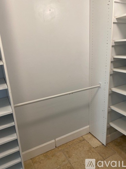 A white shelving unit with a white wall behind it.