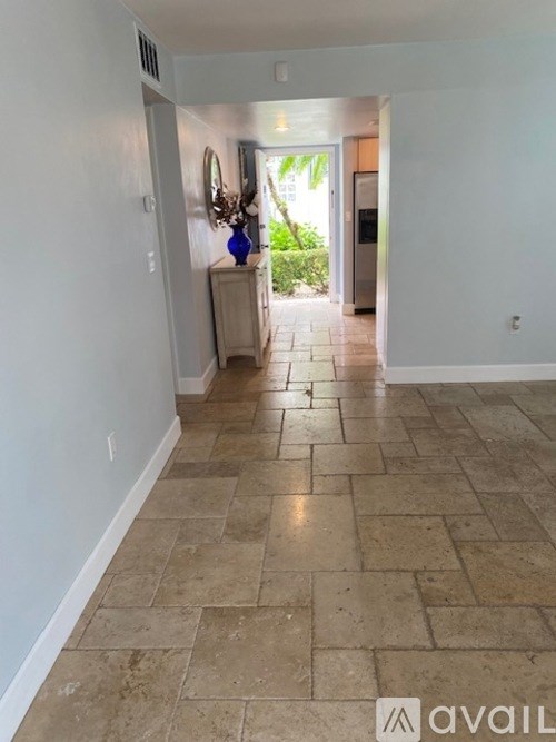 A hallway with tiled flooring and white walls.