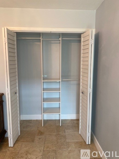 A room with a white door and a shelf inside.