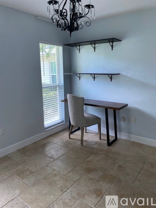 A room with a table and chairs and a chandelier.